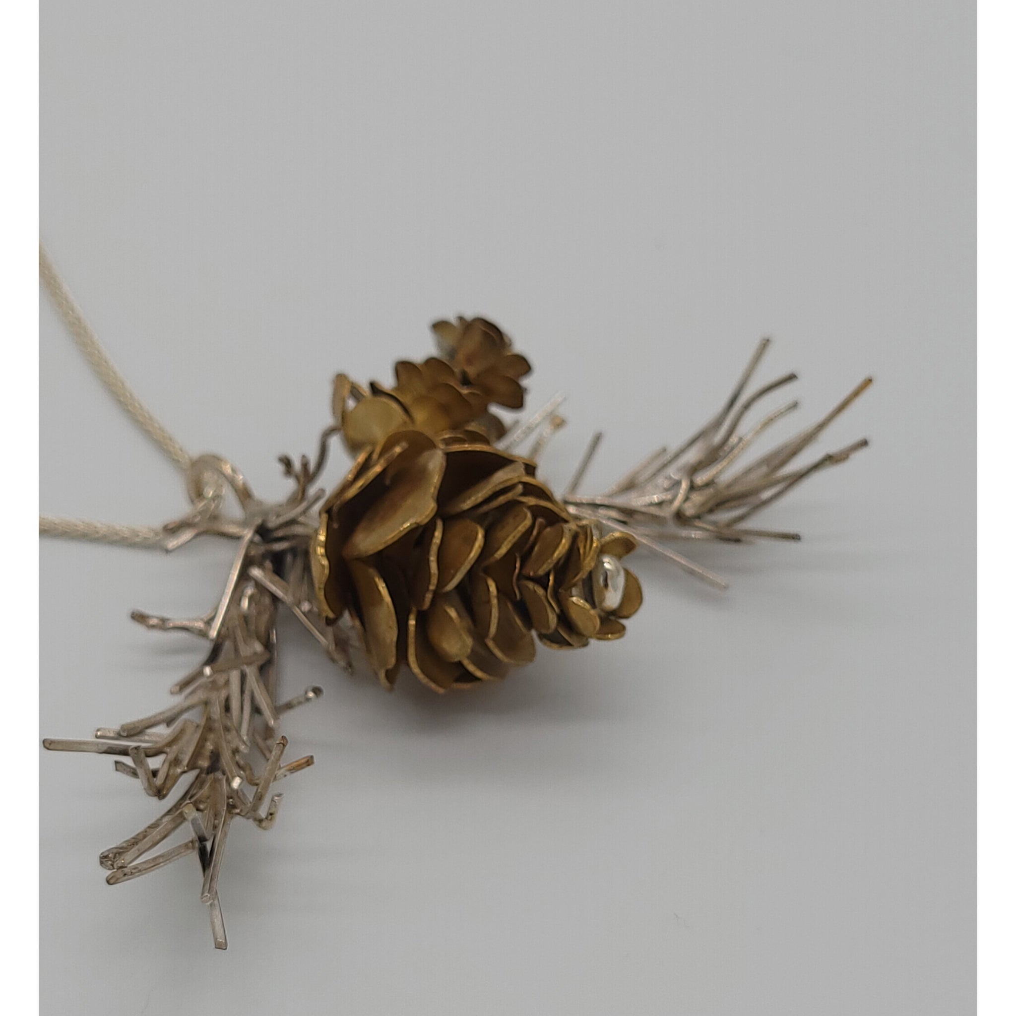 https://www.sweetheartgallery.com/cdn/shop/products/Silver-Garden-Designs-Brass-Pine-Cones-and-Sterling-Silver-Bough-Necklace-NB26-1-Artistic-Artisan-Designer-Jewelry.jpg?v=1653591605